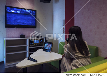 一個女人在卡拉OK箱唱歌的圖像材料 66444578