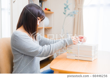 A woman who puts used books together. 66446256