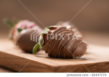 Chocolate covered fresh strawberry on wood background Chocolate covered fresh strawberry on wood background 66447574
