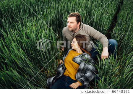 Beautiful hugging couple in love in an early wheat field Beautiful hugging couple in love in an early wheat field 66448151