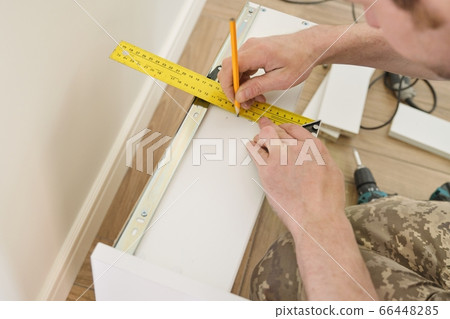 Closeup of furniture assembly with professional tools. 66448285