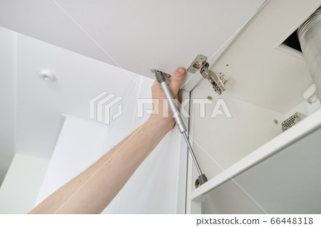 Installation of furniture. Closeup of workers hand and furniture details Installation of furniture. Closeup of workers hand and furniture details 66448318