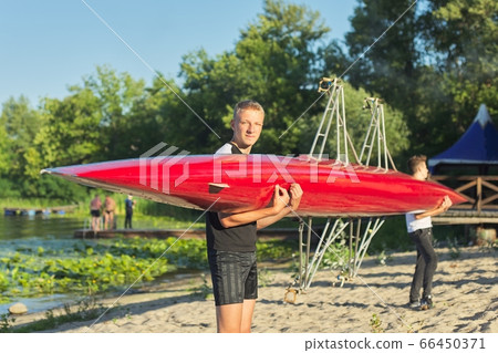 Boys teenagers walking with sports boat kayaking to river Boys teenagers walking with sports boat kayaking to river 66450371