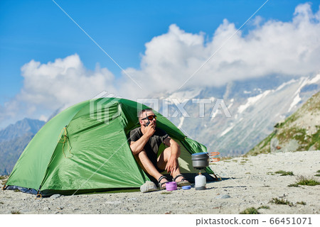 Hiker talking on radio while resting in mountains. Hiker talking on radio while resting in mountains. 66451071