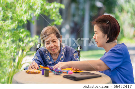 Elderly woman with caregiver in the needle crafts Elderly woman with caregiver in the needle crafts 66452417