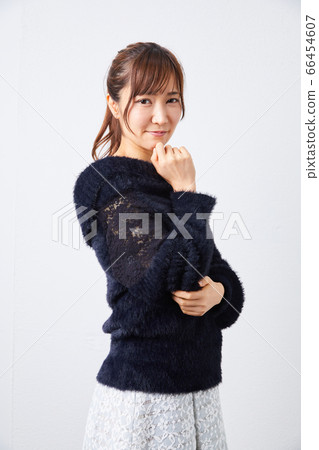 Woman in black long-sleeved knit looking at camera Woman in black long-sleeved knit looking at camera 66454607