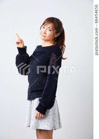Woman in black long-sleeved knit looking at camera 66454656