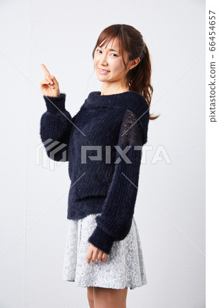 Woman in black long-sleeved knit looking at camera 66454657