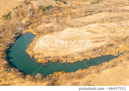 Belarus. Aerial View Of Dry Grass And Curved Bog Marsh Swamp Wetland Landscape In Early Spring Day. High Attitude View. Marsh Bog. Drone View. Bird's Eye View Belarus. Aerial View Of Dry Grass And Curved Bog Marsh Swamp Wetland Landscape In Early Spring Day. High Attitude View. Marsh Bog. Drone View. Bird's Eye View 66457531