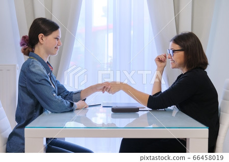 Female social worker talking to a teenage girl Female social worker talking to a teenage girl 66458019