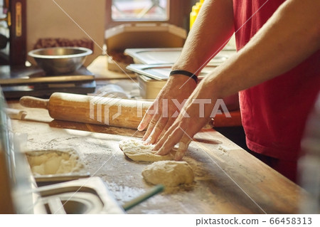 Hands of male baker with flour dough preparing food on wooden table 66458313