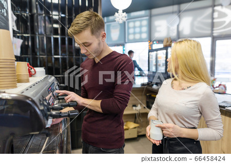 Barista man and woman making coffee, couple of young people working in coffee shop 66458424