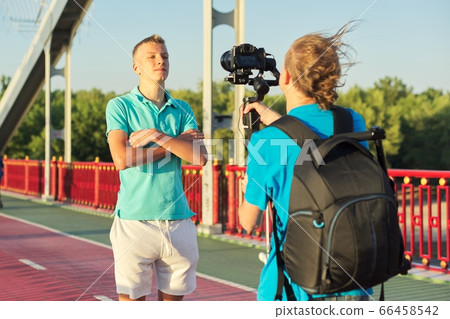 Boy teenager model and male photographer taking photos videos with camera and stabilizer 66458542