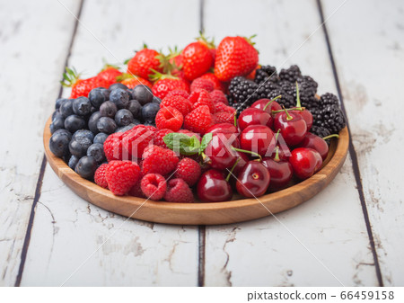 Fresh organic summer berries mix in round wooden Fresh organic summer berries mix in round wooden 66459158
