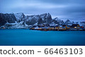Classic illuminated yellow waterfront rorbu in Reine, Lofoten island, Norway 66463103