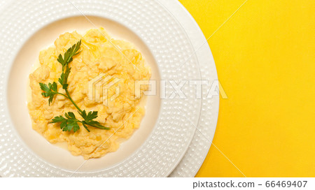 scramble omelette in a white plate on a yellow 66469407