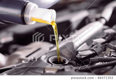 Motor oil pouring to car engine. Motor oil pouring to car engine. 66471303