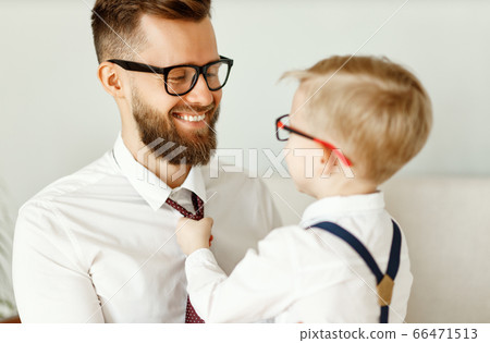 happy son helps father tie a necktie at home. happy son helps father tie a necktie at home. 66471513