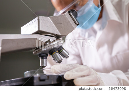 Asian scientist looking through a microscope for research and analysis chemical test in laboratory Asian scientist looking through a microscope for research and analysis chemical test in laboratory 66472098