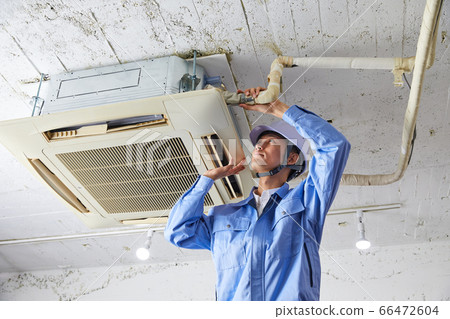 Businessman in work clothes repairing a commercial air conditioner 66472604