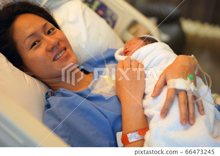 Asian Chinese woman holding her new born baby Asian Chinese woman holding her new born baby 66473245