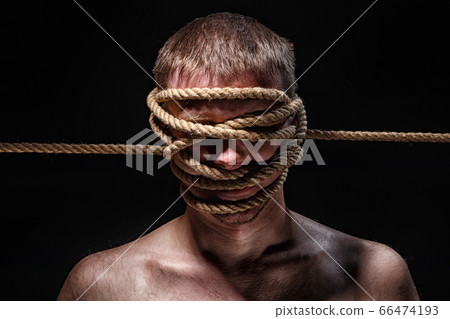 Photo of binded man with rope on face 66474193