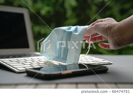 Work at home. Woman holding medical face mask on Work at home. Woman holding medical face mask on 66474781