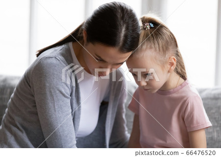 Close up caring young mother calming offended little daughter 66476520