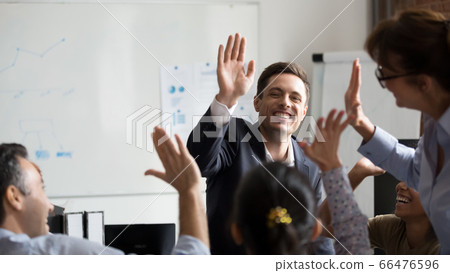 Happy diverse employees giving high five at company briefing 66476596