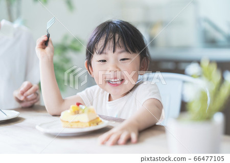 父母和孩子在房間的桌上吃蛋糕 父母和孩子在房間的桌上吃蛋糕 66477105