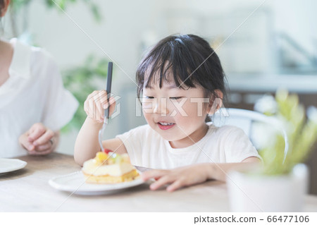 父母和孩子在房間的桌上吃蛋糕 66477106