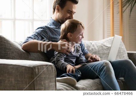 Happy father and little son using laptop together, having fun Happy father and little son using laptop together, having fun 66478466
