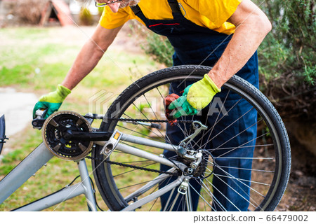 Man maintaining his bicycle for the new season 66479002