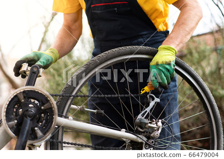 Man lubricating bicycle chain maintaining for the 66479004