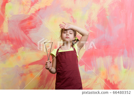 small tired girl chef in cook apron holding 66480352