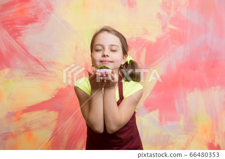 Baby girl with closed eyes enjoy eating cupcake Baby girl with closed eyes enjoy eating cupcake 66480353