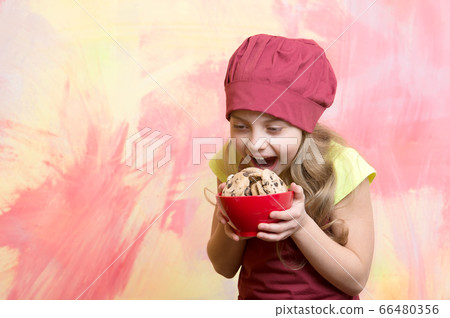 small girl in red chef hat, apron with chocolate 66480356