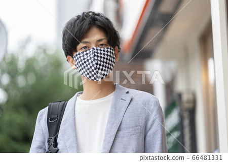 Young man wearing a checkered mask 66481331