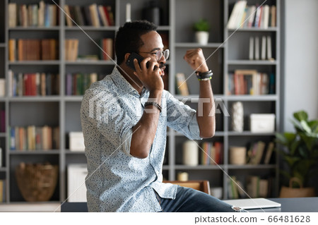 African man talking by cellphone received great news feels happy African man talking by cellphone received great news feels happy 66481628