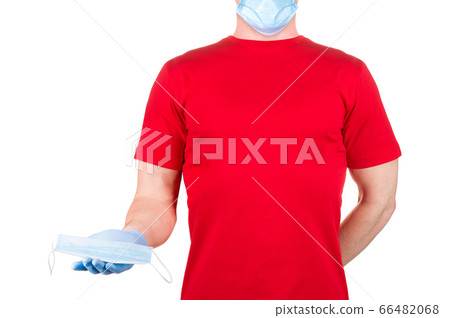 Man in red t-shirt holding disposable face mask isolated white background Man in red t-shirt holding disposable face mask isolated white background 66482068