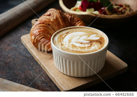 A cup of coffee with latte art on top, butter  66482688