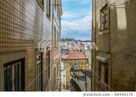 Traditional narrow street  in Alfama district 66484178