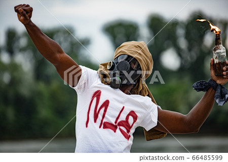 aggressive man throw fire bottle with cloth in the streets 66485599