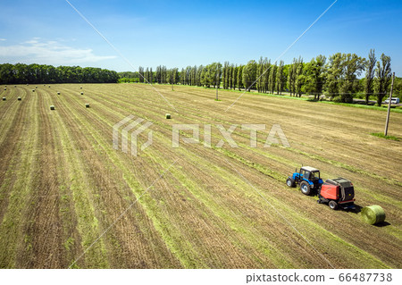 Tractor and round baler discharges. Straw Bales 66487738