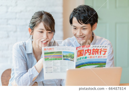 Men and women making plans while looking at travel brochures Men and women making plans while looking at travel brochures 66487814