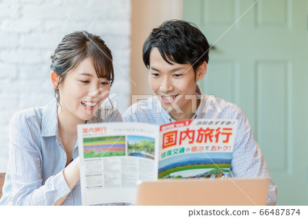 Men and women making plans while looking at travel brochures Men and women making plans while looking at travel brochures 66487874