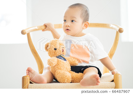 A little boy sitting on chair 66487907