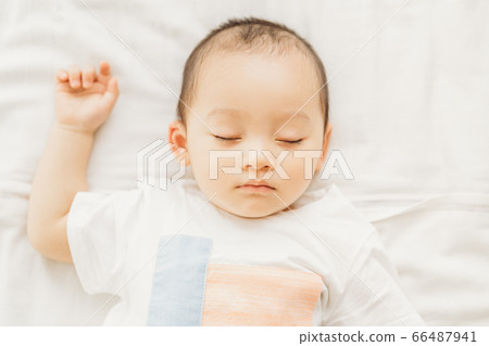 A little boy sleeping on the bed 66487941