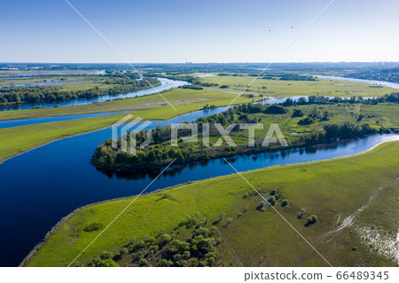 Scenic aerial view of a river and green fields in a countryside Scenic aerial view of a river and green fields in a countryside 66489345