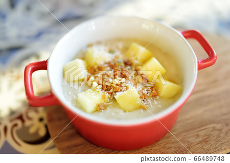 Pudding with fruits, nuts and seeds in red bowl  66489748